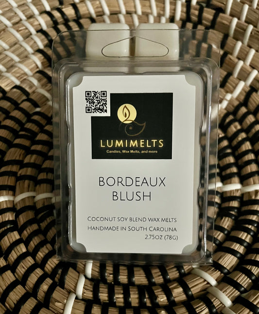 Lumimelts Bordeaux Blush wax melt on a woven surface